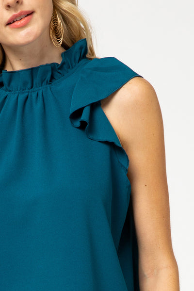 Close up view of ruffle sleeve and ruffle neck blouse in teal.