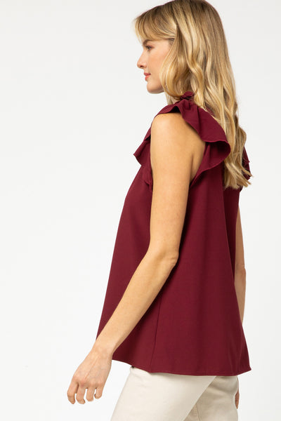 Side view of ruffle sleeve burgundy blouse with good length for long torsos.