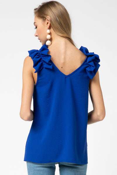 Back view of royal blue top for fall with back v-neck and ruffle sleeveless strap.