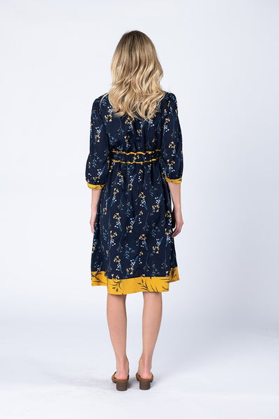 Back view of knee length 3/4 sleeve floral dress with hidden elastic waist band at back.
