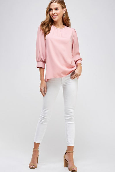 Cute women's 3/4 sleeve blouse with cuffs in dusty rose shown with white jeans.