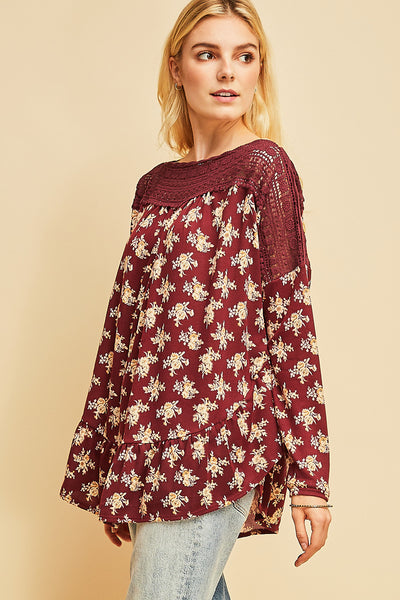 Boho top with crocheted neck and shoulder with long sleeves in burgundy floral. Ruffle along rounded hemline.