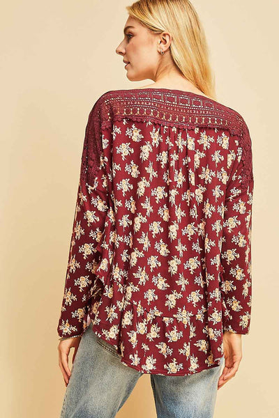 Back view of burgundy floral top with ruffle hem with full coverage length. Crochet across neck and shoulders is semi-sheer.