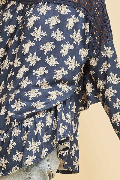 Close up view of ruffle detail along hemline and side seem in blue with white flowers.