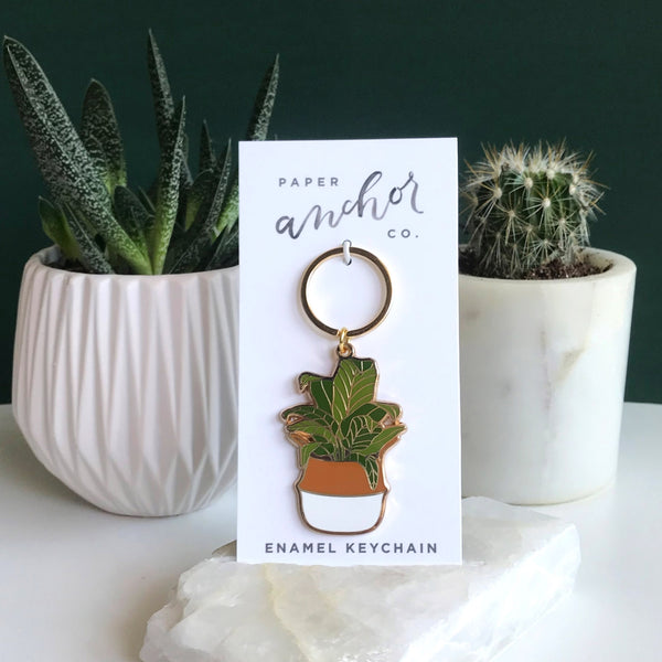 Gifts for plant lovers. Banana leaf keychain sitting in front of succulents.