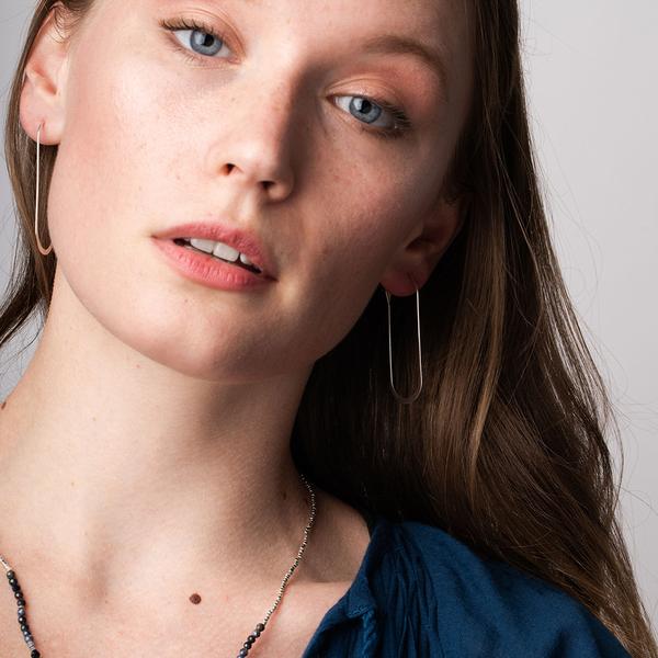 Unique lightweight hoop earrings worn by model.