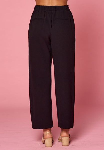 Back view of women's pleated black slacks with faux back pockets and back elastic waist.