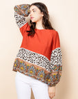 Elegant red top with bands of animal and paisley prints along lower half.