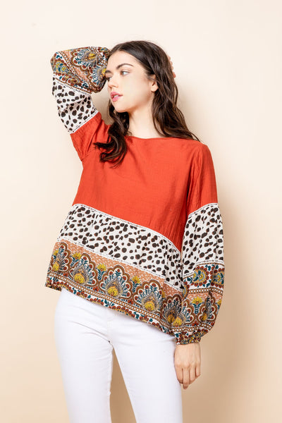 Elegant red top with bands of animal and paisley prints along lower half.