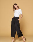 Women's black button front pants with four button closure and wide legs. Pockets. Culottes.