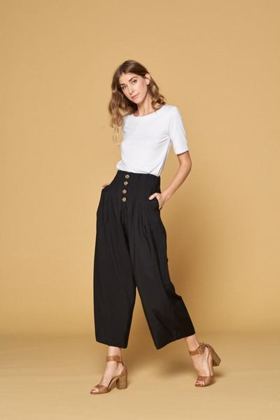 Women's black button front pants with four button closure and wide legs. Pockets. Culottes.