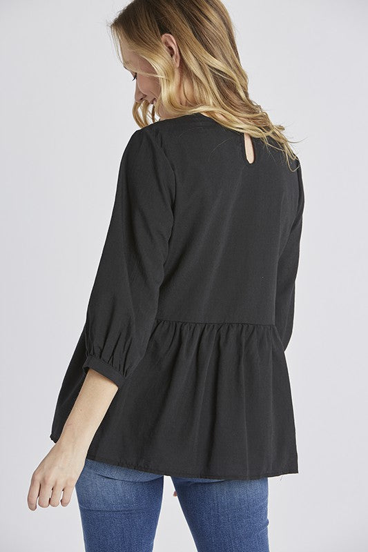 Back view of Women&#39;s embroidered peasant top. - Black with half sleeves and peplum cut.