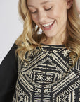 Close up of embroidery on Women's embroidered peasant top. - Black with half sleeves and peplum cut.