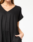 Close up of black knit maxi v-neck and rolled short sleeves.