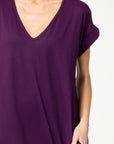 Plum knit maxi closeup of v-neck and rolled short sleeves.