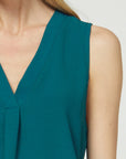 Close up view of sleeveless v-neck blouse with pleated placket at front.