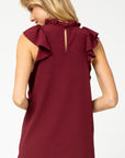 Back view of burgundy ruffle neck and sleeve top with keyhole closure.