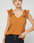 Fall fashion 2020 in camel colored v-neck sleeveless blouse with ruffle at strap.