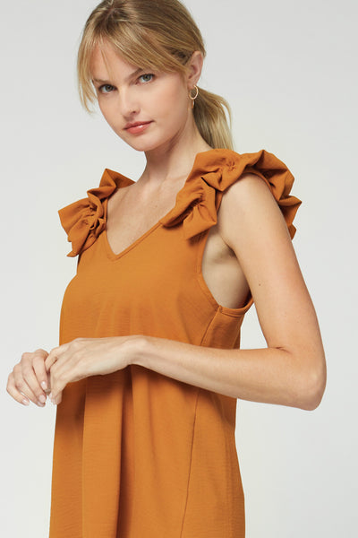 Side view of camel colored v-neck sleeveless top with ruffle strap.
