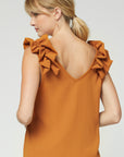 Back view of camel colored sleeveless top with ruffle at strap and v-neck back.