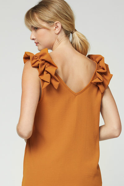 Back view of camel colored sleeveless top with ruffle at strap and v-neck back.