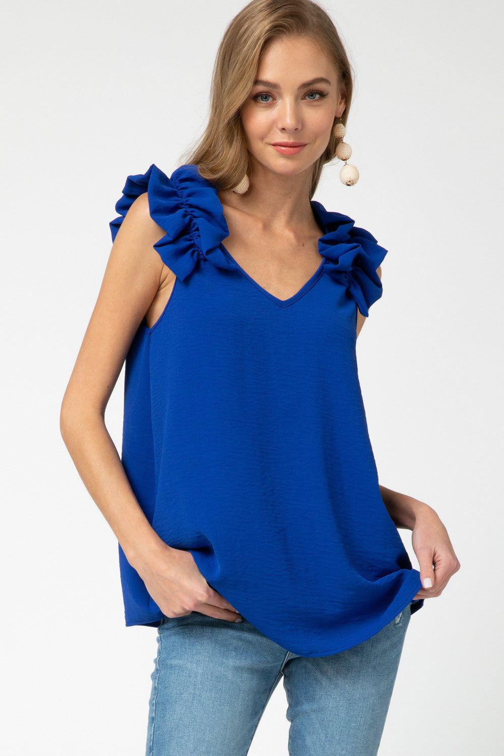 Fall fashion 2020. Royal blue sleeveless top with beautiful ruffle accents on straps. V-neck.