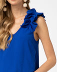 Close up view of ruffle detail at sleeveless strap on royal blue top.