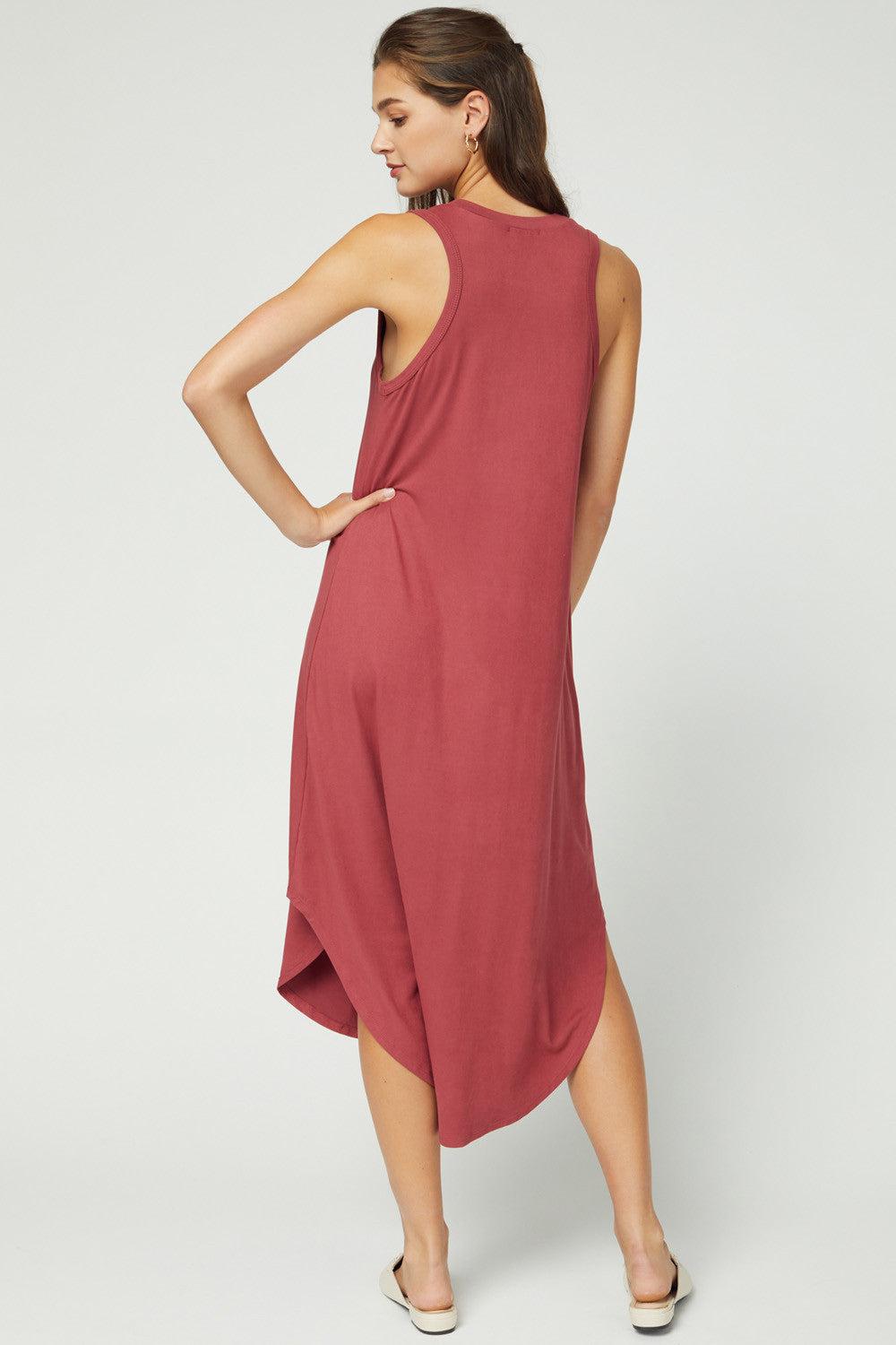 Back view of longer back hemline and sleeveless cut with slight cut in/racerback shape in color marsala.