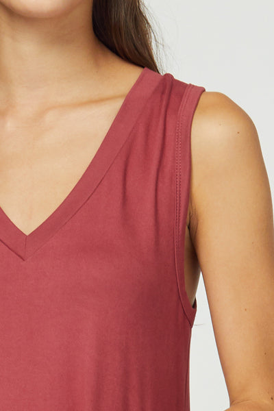 Up close view of v-neck and sleeveless cuts of dress in marsala.