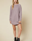 Full view of women's long sleeve dress in mocha heather sweater material paired with black booties. Super soft.