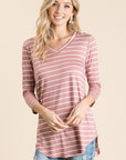 Untucked view of 3/4 sleeve tunic with v-neck in mauve with white stripes paired with jeans.