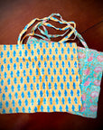 Reusable grocery bags foldable. Yellow with blue flowers pattern. Aqua with pink flowers pattern.