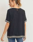 Back view of boho style embroidered top in black.