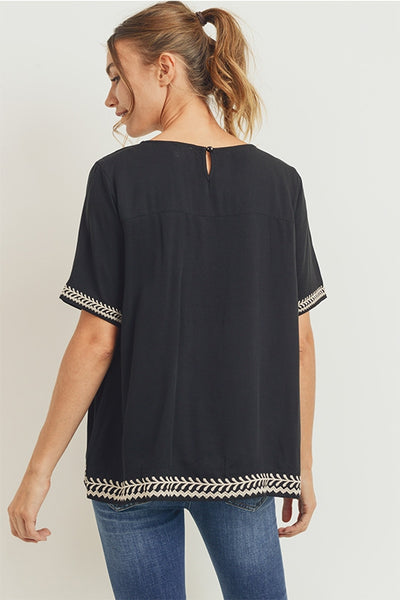 Back view of boho style embroidered top in black.