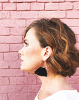 Black tassel hoop earrings on model.