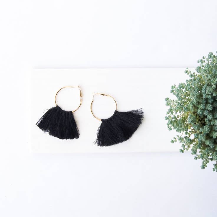 Black tassel hoop earrings in gold metal.