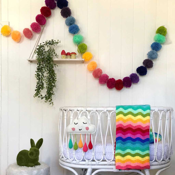 Unique baby gifts. Rainbow cloud mobile displayed in nursery.