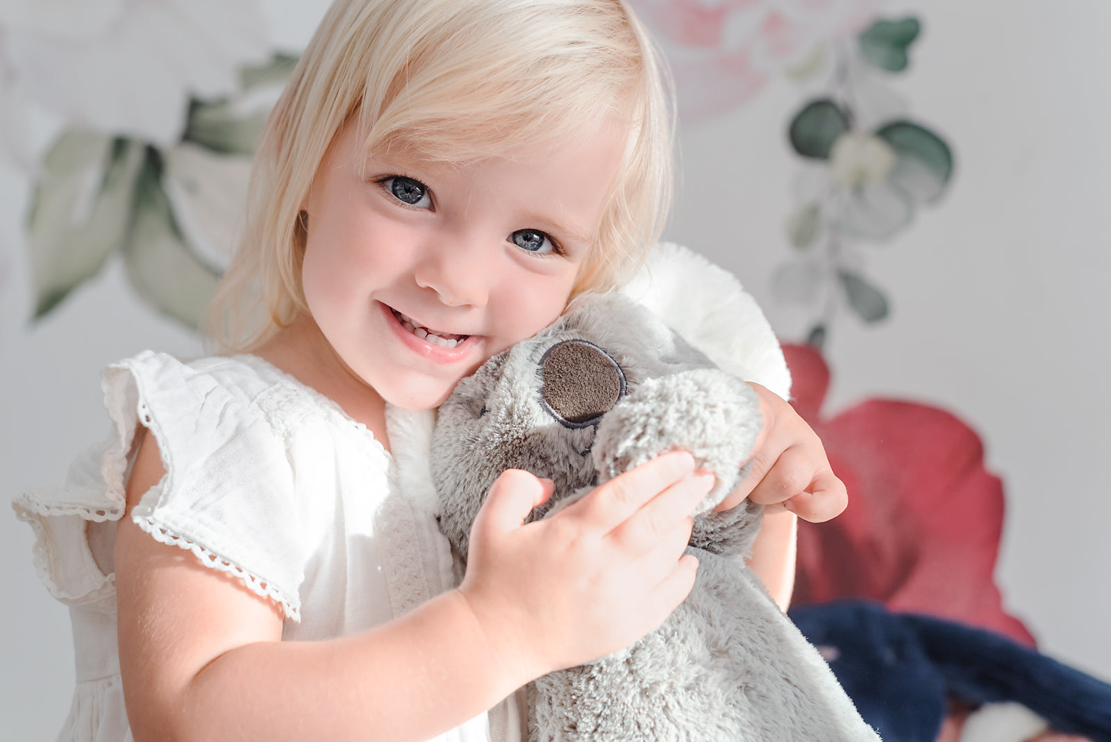 Child holding Koala Stuffed Animal. Grey.