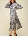 Full skirt tiered maxi with button up bodice and long sleeves in snake print paired with black strappy heals.