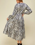 Back view of long sleeve tiered skirt maxi dress with grey snake print.