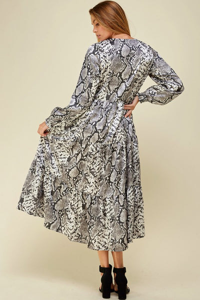 Back view of long sleeve tiered skirt maxi dress with grey snake print.