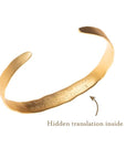 Inside of engraved echo cuff shown in gold with hidden translation of sound wave imprinted on inside.