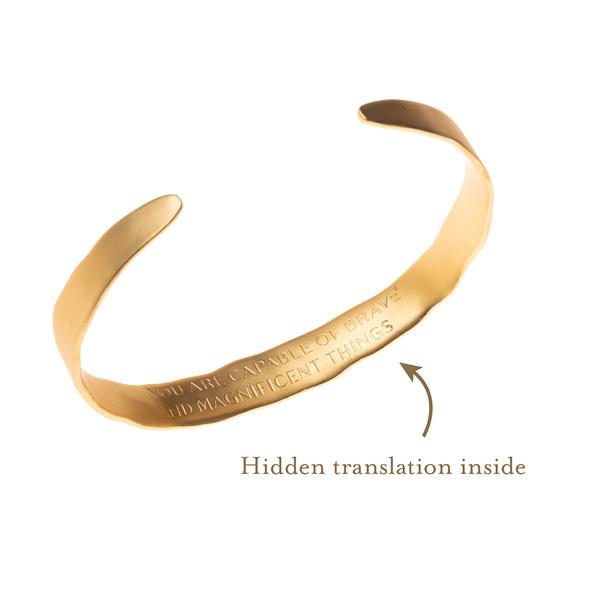 Engraved bracelets for women. Inside of engraved echo cuff shown in gold with hidden translation of sound wave imprinted on inside.
