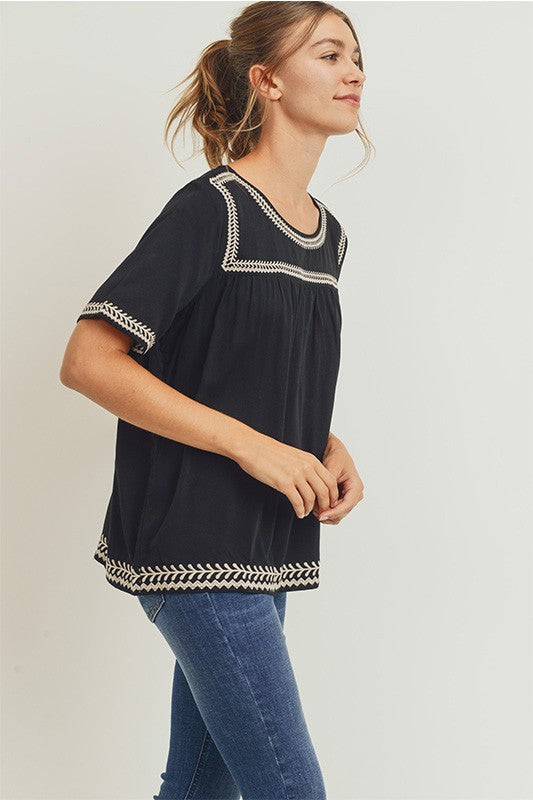 Women&#39;s boho style embroidered top in black with off-white embroidery. Short sleeve relaxed fit.