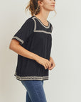 Women's boho style embroidered top in black with off-white embroidery. Short sleeve relaxed fit.