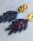 Gold statement earrings with acrylic leaves.