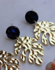 Gold leaf earrings with dark blue acrylic stud.