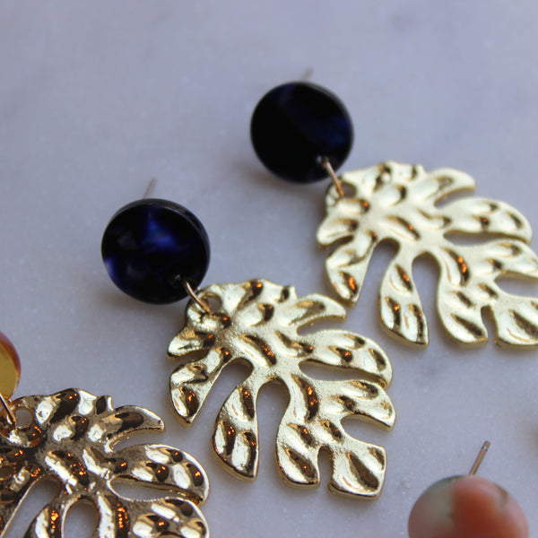 Gold leaf earrings with dark blue acrylic stud.