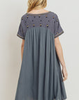 Back view of relaxed fit boho dress with embroidery at yoke and sleeves.