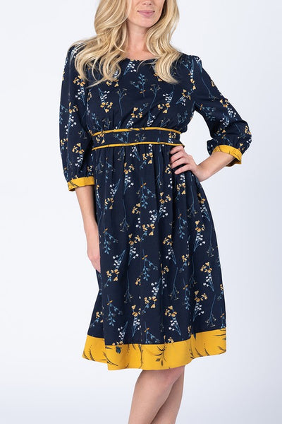 3/4 sleeve dress with navy background and little yellow flower print with yellow band at knee length hem.